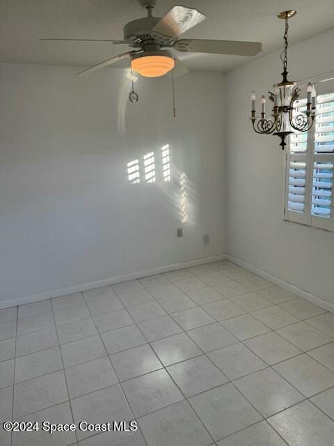 empty room featuring light tile patterned floors and an inviting chandelier