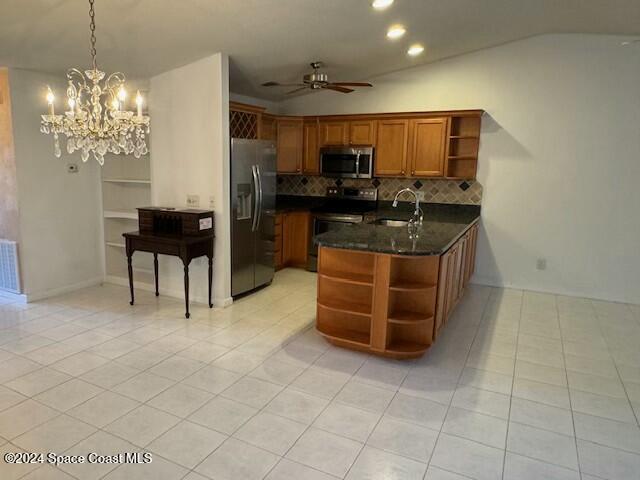 kitchen with ceiling fan with notable chandelier, sink, appliances with stainless steel finishes, decorative light fixtures, and kitchen peninsula