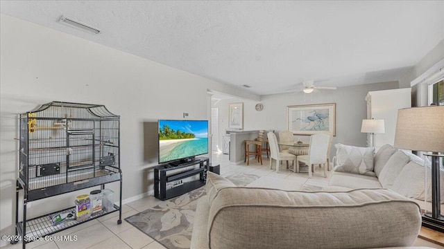 tiled living room featuring ceiling fan and a textured ceiling