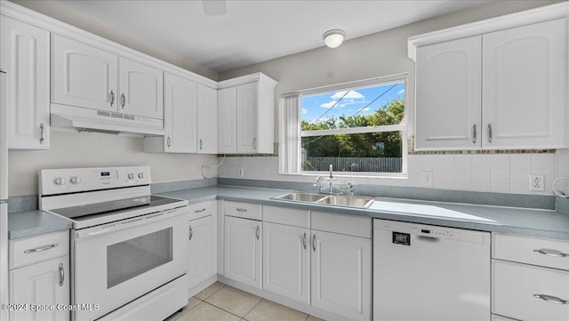 kitchen with decorative backsplash, sink, white cabinets, and white appliances