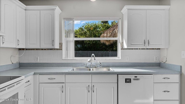 kitchen featuring backsplash, white dishwasher, white cabinetry, and sink