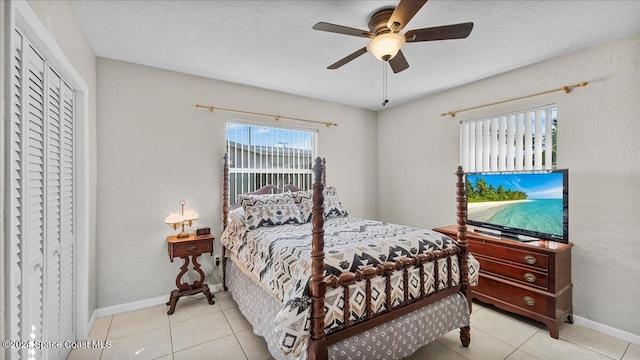 bedroom with ceiling fan, light tile patterned floors, and a closet