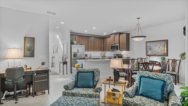 kitchen with hanging light fixtures, light tile patterned floors, and stainless steel appliances