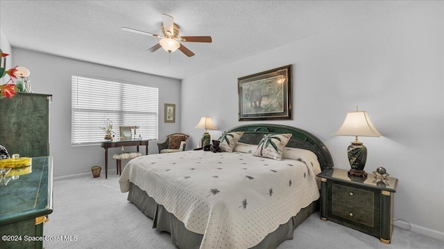 bedroom with a textured ceiling, light colored carpet, and ceiling fan