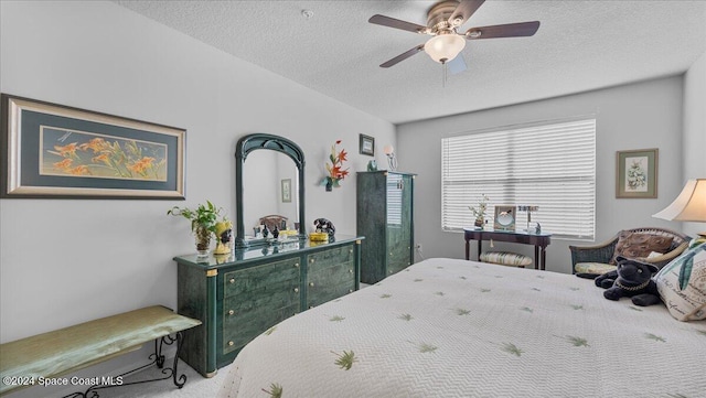 carpeted bedroom with ceiling fan and a textured ceiling