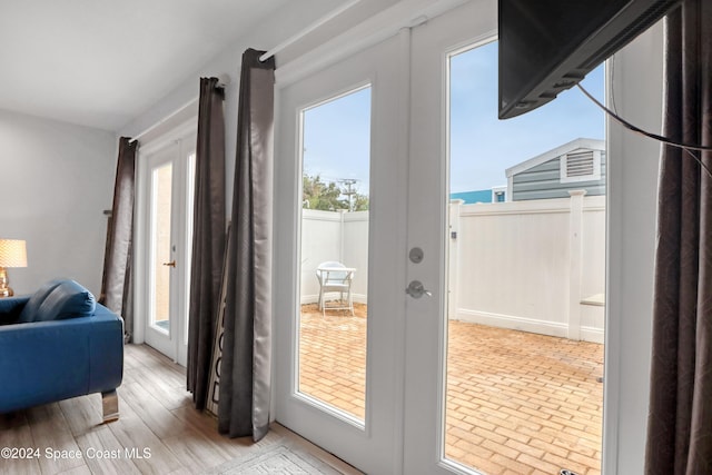 entryway featuring french doors, a healthy amount of sunlight, and light hardwood / wood-style flooring