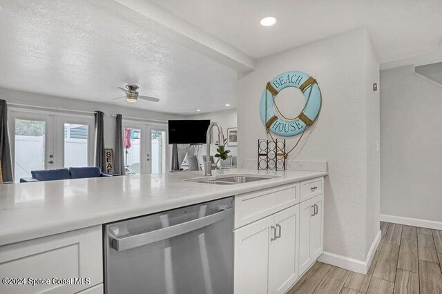 kitchen featuring white cabinetry, french doors, ceiling fan, stainless steel dishwasher, and light hardwood / wood-style floors