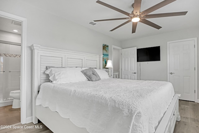 bedroom with connected bathroom, ceiling fan, and hardwood / wood-style floors