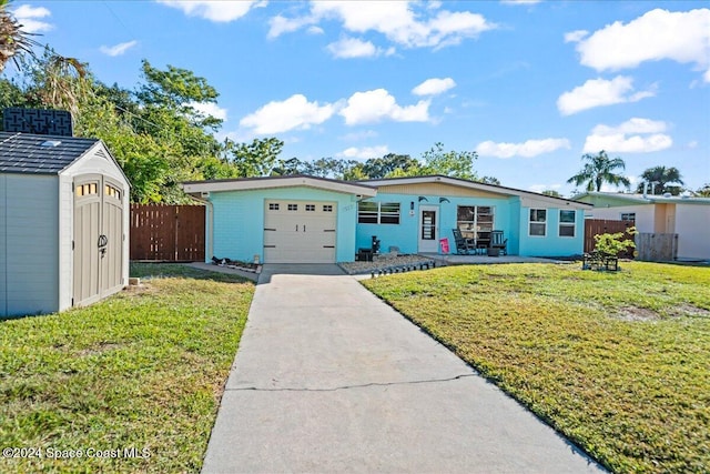 ranch-style home featuring a garage, a front lawn, and a storage shed