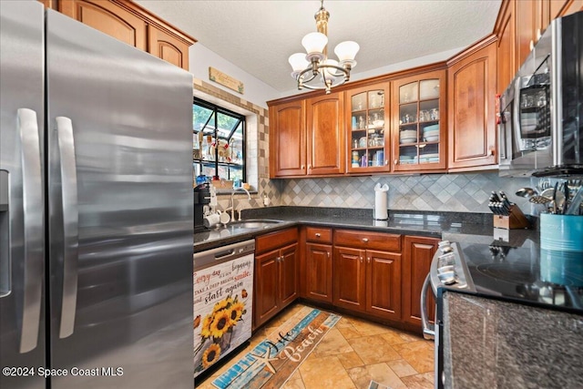 kitchen featuring pendant lighting, an inviting chandelier, sink, decorative backsplash, and stainless steel appliances