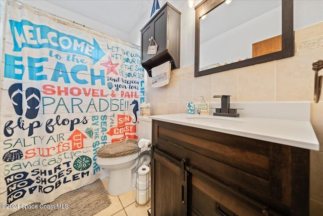 bathroom featuring vanity, backsplash, tile patterned flooring, toilet, and tile walls