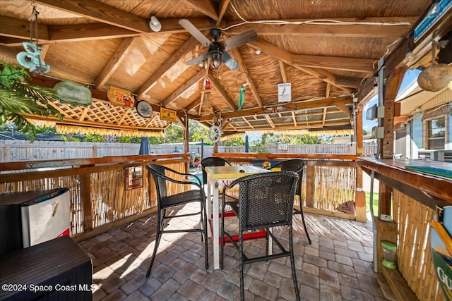 view of patio featuring a gazebo, ceiling fan, and exterior bar