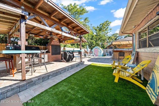 view of yard featuring a gazebo, ceiling fan, an outdoor bar, and a patio