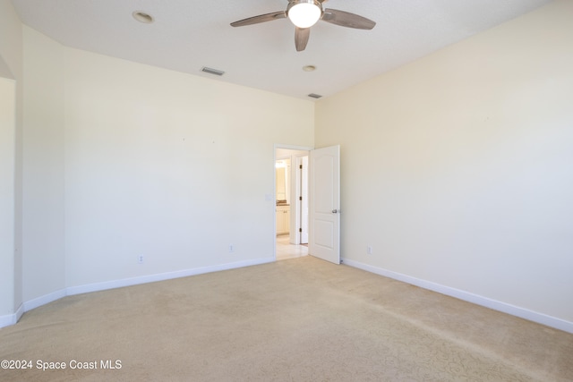 carpeted spare room with ceiling fan