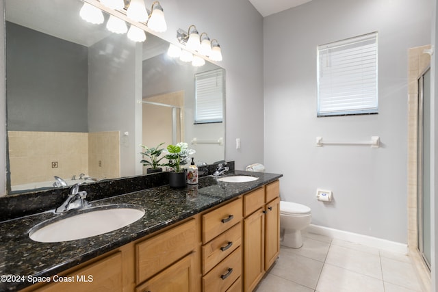 bathroom featuring tile patterned flooring, vanity, toilet, and an enclosed shower