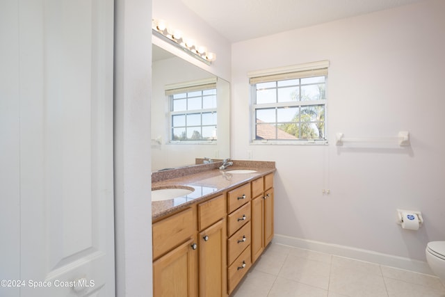 bathroom with tile patterned flooring, vanity, and toilet