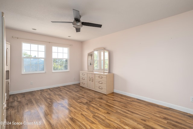 unfurnished bedroom featuring ceiling fan and dark wood-type flooring