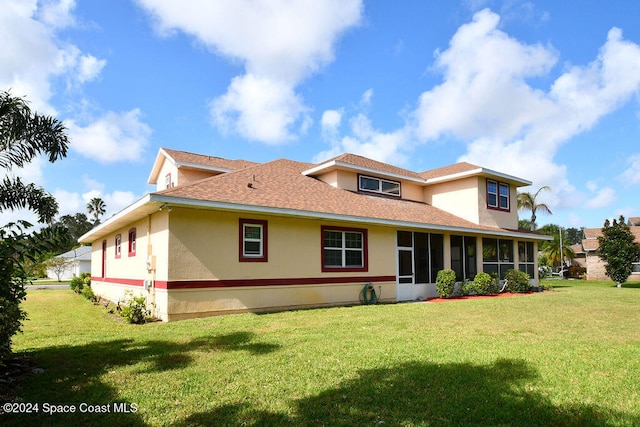 back of property with a sunroom and a yard