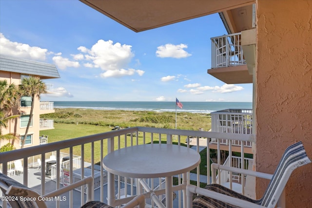 balcony featuring a water view and a view of the beach