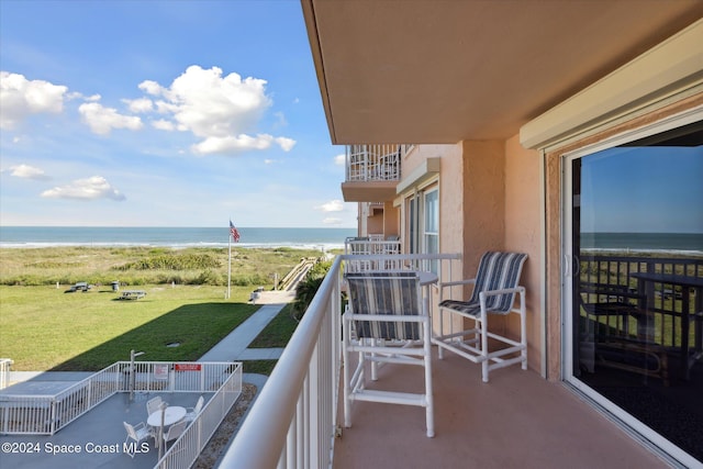 balcony featuring a water view and a view of the beach