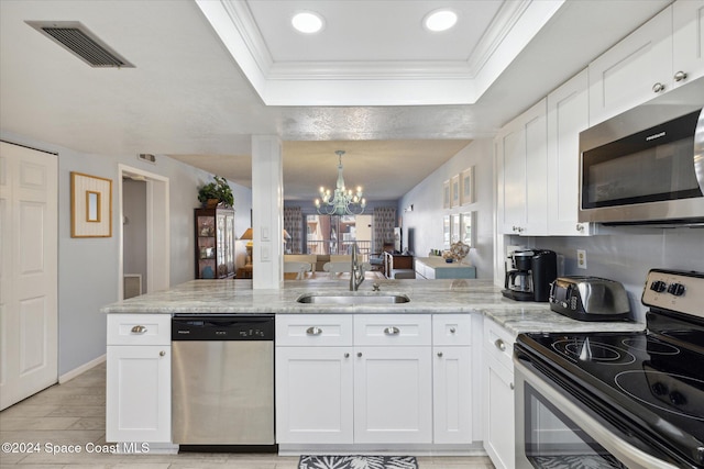 kitchen with sink, kitchen peninsula, a chandelier, white cabinets, and appliances with stainless steel finishes