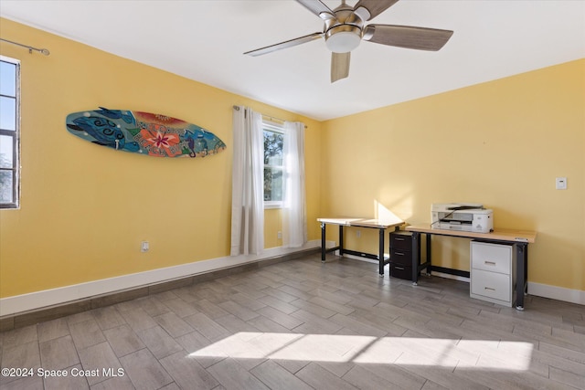 unfurnished office with ceiling fan and light wood-type flooring