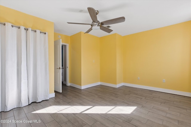 spare room featuring ceiling fan and light hardwood / wood-style floors