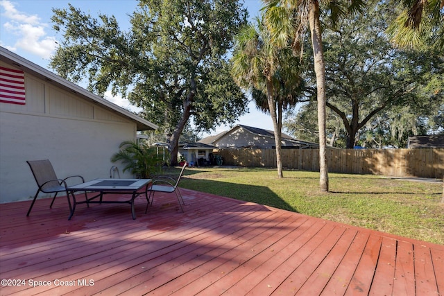 wooden deck featuring a lawn