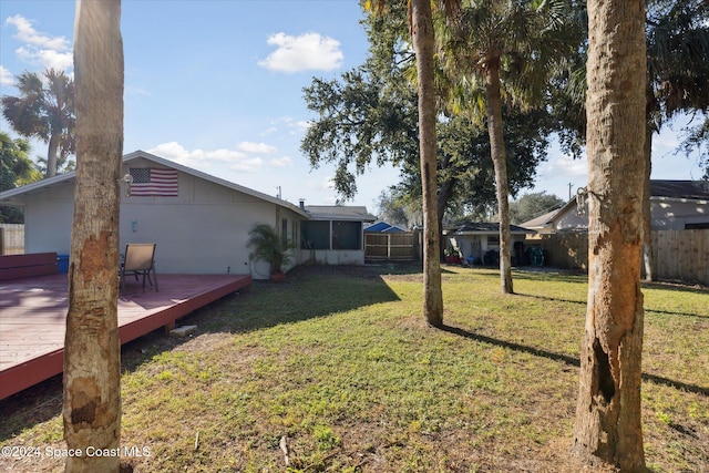 view of yard with a sunroom and a wooden deck