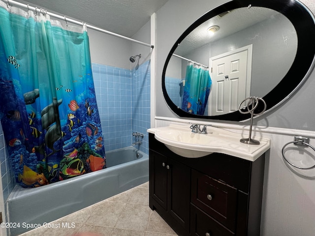 bathroom with vanity, a textured ceiling, tile patterned floors, and shower / bath combo with shower curtain