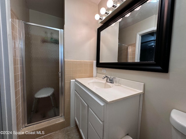 bathroom featuring tile patterned floors, vanity, an enclosed shower, and toilet