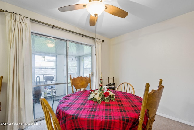 carpeted dining room with ceiling fan