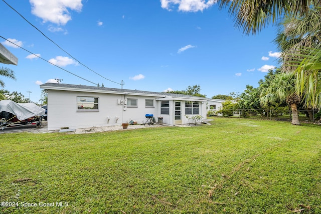 rear view of property with a yard