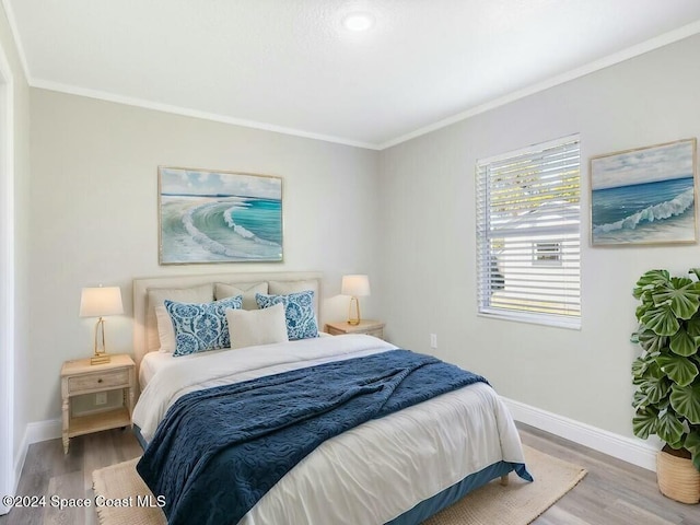 bedroom with wood-type flooring and ornamental molding