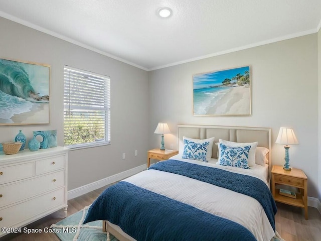 bedroom with hardwood / wood-style floors and ornamental molding