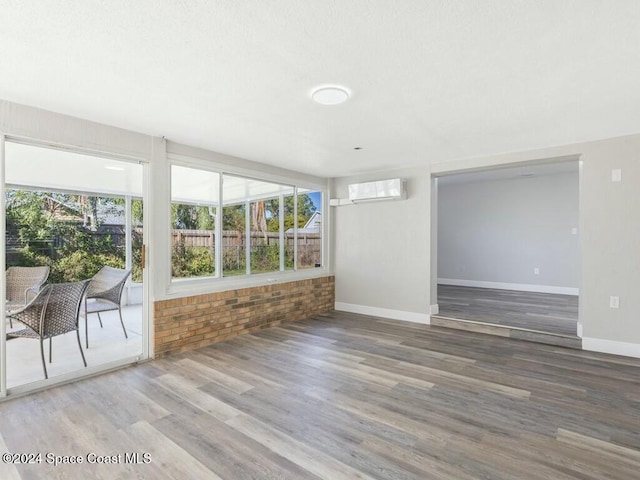 spare room with hardwood / wood-style flooring and a wall mounted air conditioner