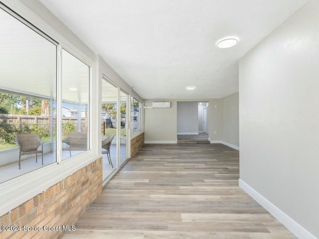 corridor featuring light hardwood / wood-style floors and a wall mounted AC