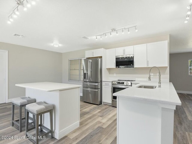 kitchen featuring white cabinets, light wood-type flooring, sink, and appliances with stainless steel finishes