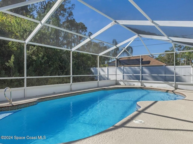 view of pool featuring glass enclosure and a patio area