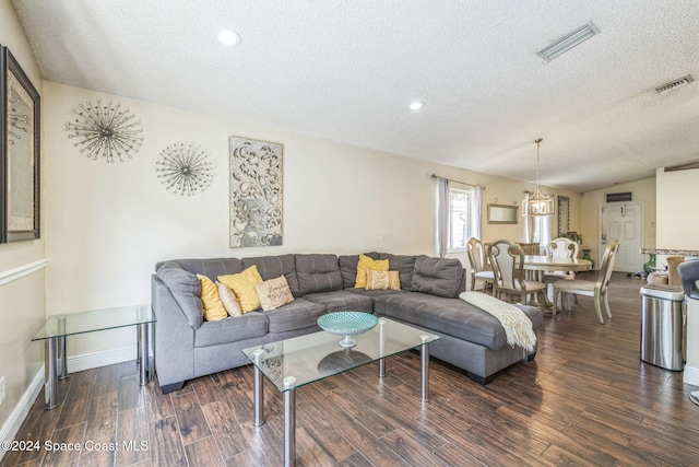 living room featuring a textured ceiling, dark hardwood / wood-style flooring, and vaulted ceiling