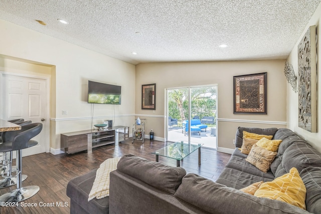 living room with a textured ceiling, vaulted ceiling, and dark wood-type flooring