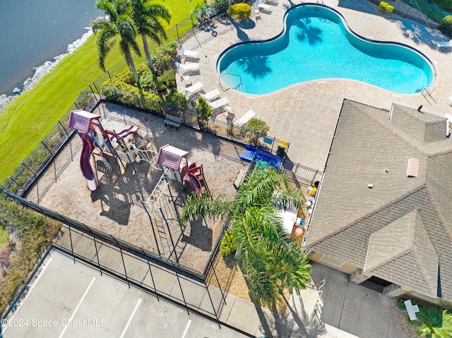 pool featuring a water view, a patio area, and fence