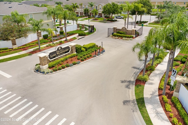 exterior space with a residential view, curbs, sidewalks, and a gated entry