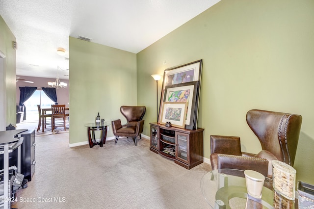 sitting room with light carpet and an inviting chandelier