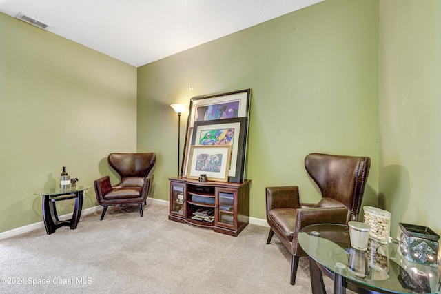 living area with carpet, visible vents, and baseboards