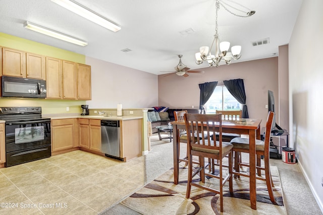 kitchen with a peninsula, black appliances, visible vents, and light brown cabinetry