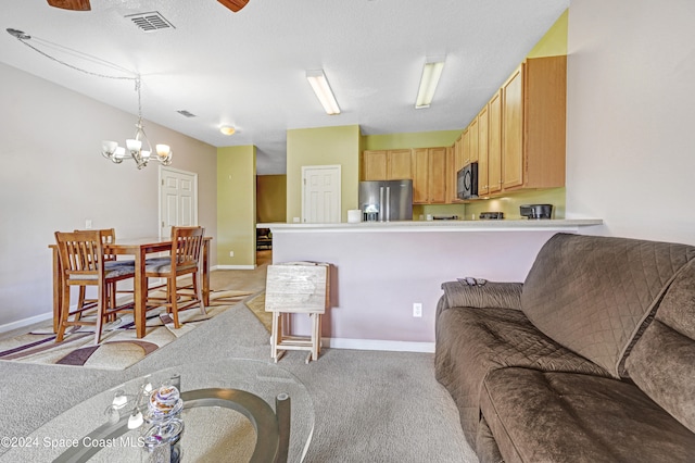 living room featuring light carpet, a textured ceiling, and an inviting chandelier