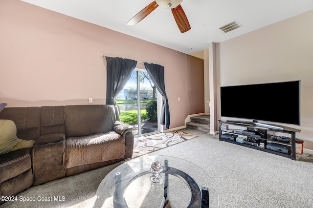 living room featuring carpet flooring, ceiling fan, visible vents, and baseboards