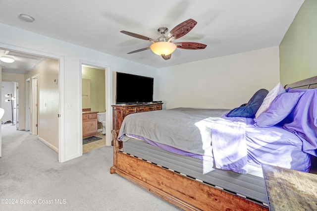 bedroom with light colored carpet, attic access, ceiling fan, ensuite bath, and baseboards