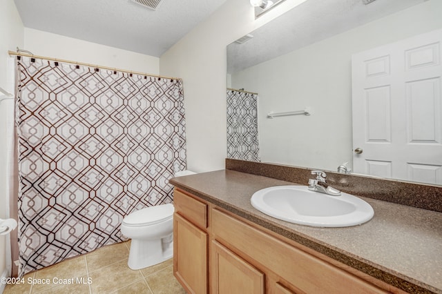 bathroom with a textured ceiling, tile patterned flooring, toilet, visible vents, and vanity